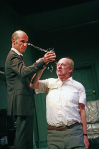 a man is pushing a glass of water out of another mans hand